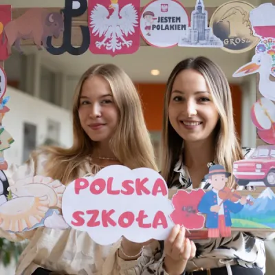 Dwie osoby prezentujące dekorację z napisem „Polska szkoła”